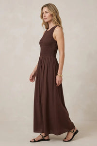A flowing sleeveless brown juniper smocked maxi dress made of soft fabric with a smocked bodice for elegant wear