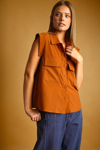 Orange sleeveless chiffon blouse with collar front pockets and button front in lightweight fabric