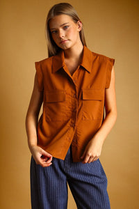 A sleeveless rust-orange chiffon blouse with pocket button front and classic collar for stylish wear