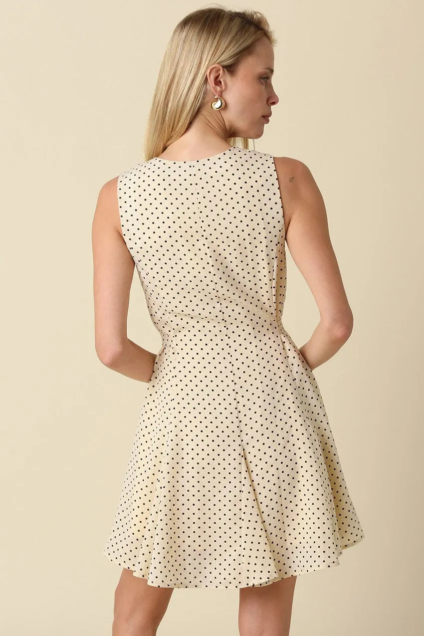 A sleeveless cream mila polka dot button front mini dress with black polka dots and a flared skirt