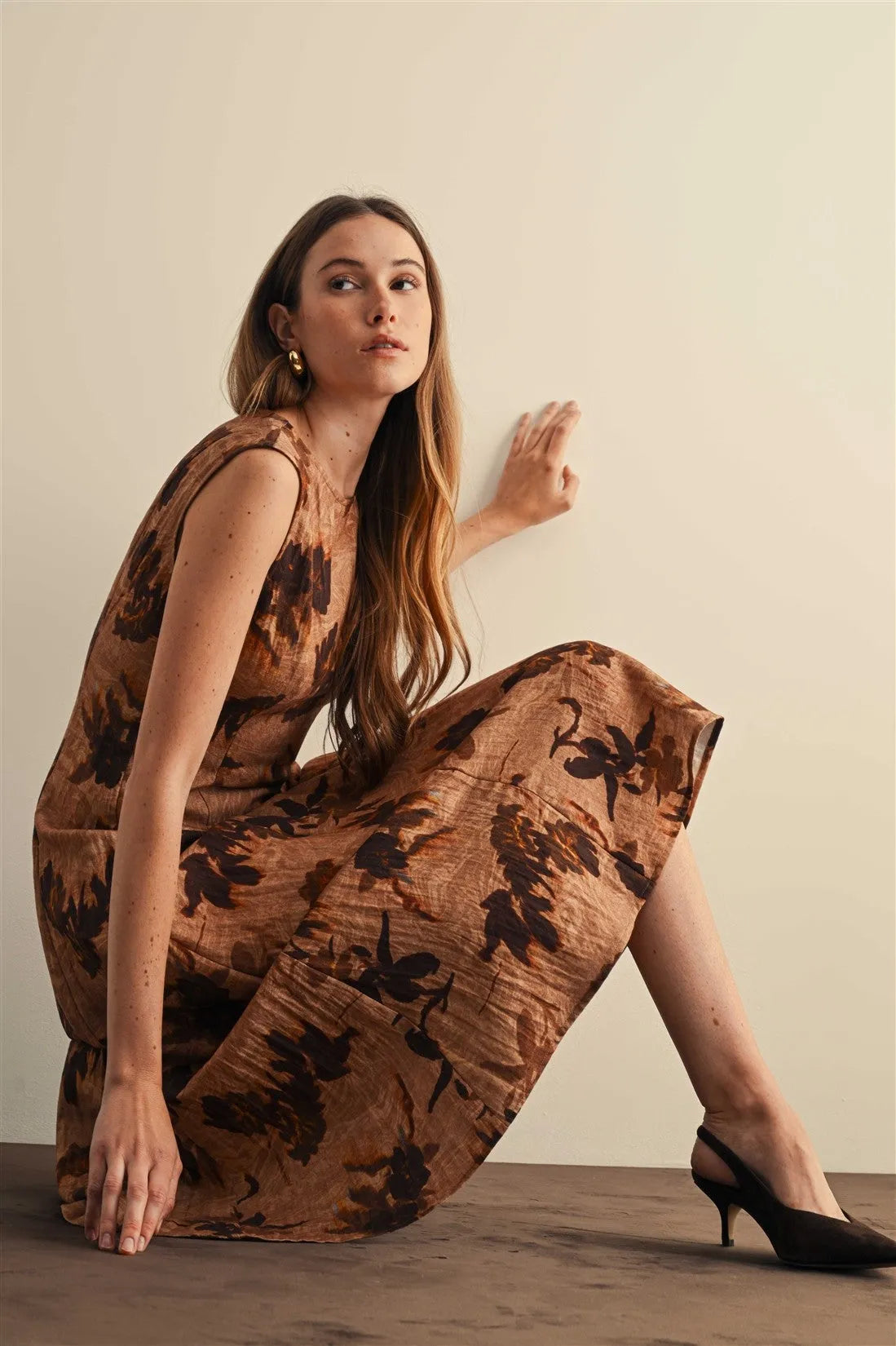 A flowing warm brown flower print sleeveless midi dress with dark floral patterns and subtle texture