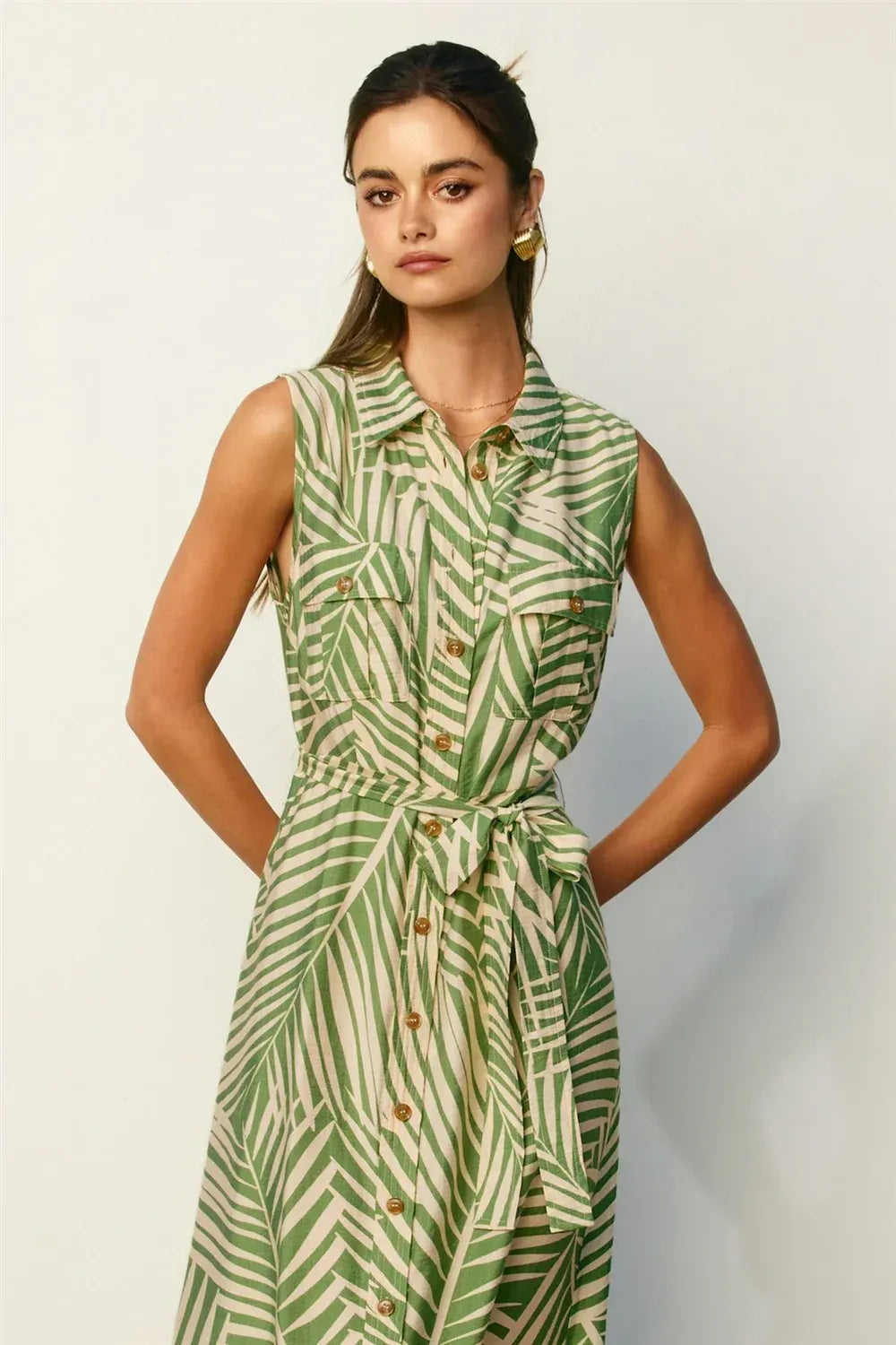 Wild tides shirt dress featuring a sleeveless green and cream leaf-patterned button-down design with belted waist