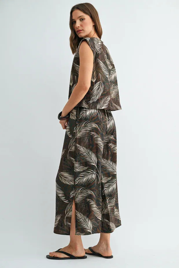 A sleeveless high waisted maxi dress in dark brown fabric with an all over white leaf print elastic waist detailing