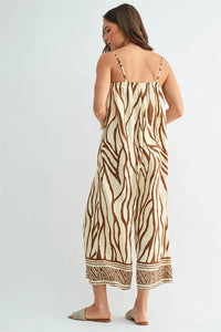 A flowing sleeveless border print jumpsuit with a bold brown and cream zebra print pattern