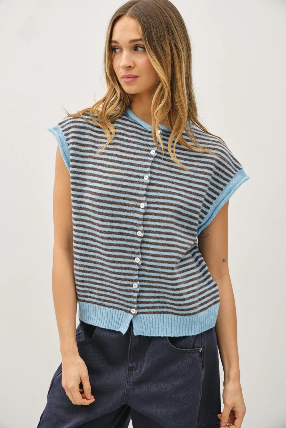 A sleeveless knit mini striped piper button top with horizontal dark gray and light blue stripes and ribbed cuffs