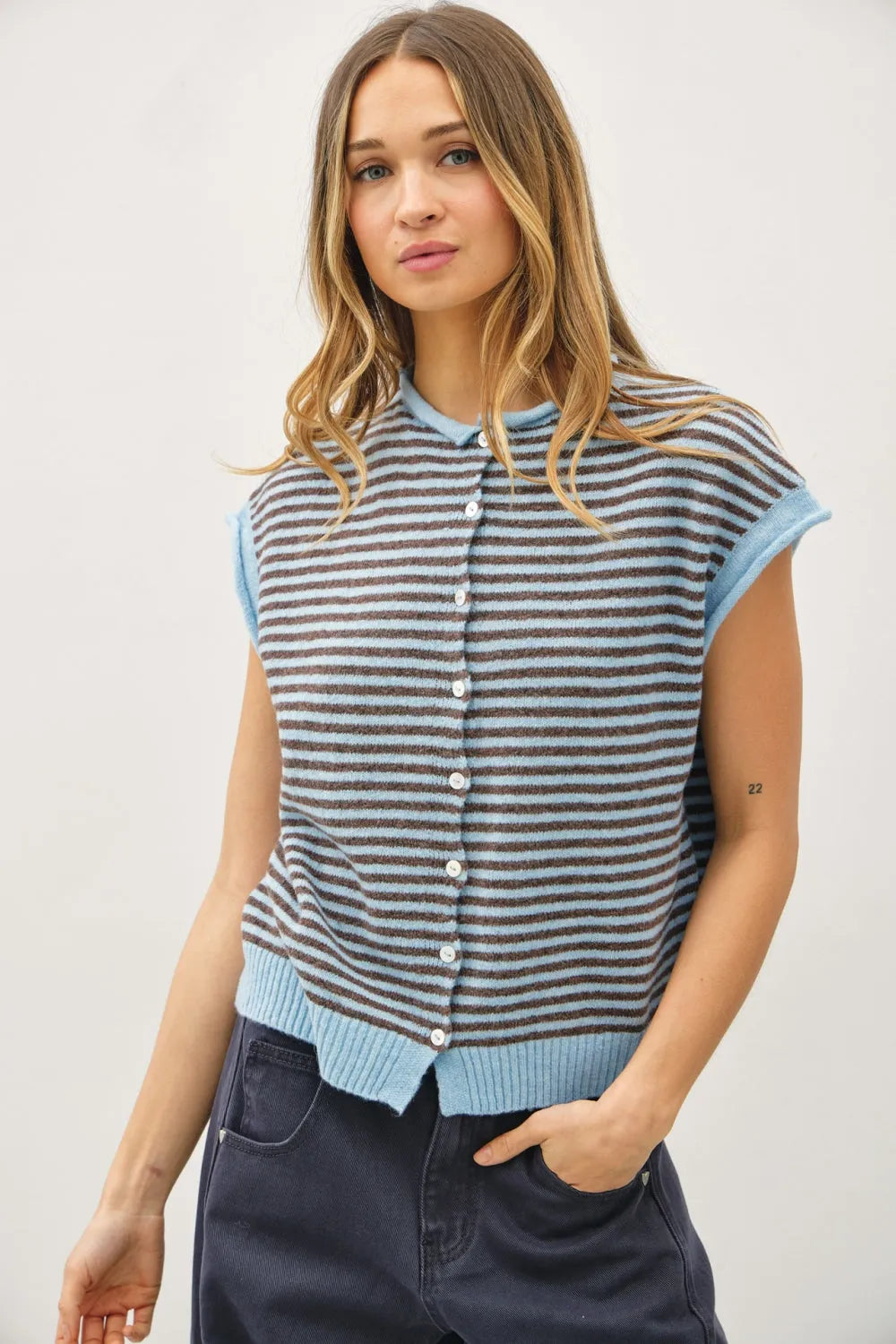 A sleeveless mini striped piper knit top with button-front closure and ribbed cuffs in gray and light blue shades