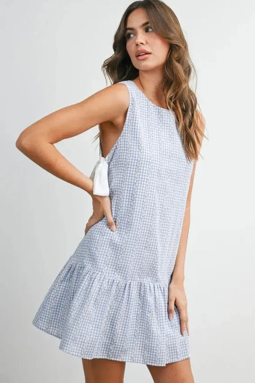 Sleeveless light blue and white gingham flounce mini dress with ruffled hem and white bow shoulder detail