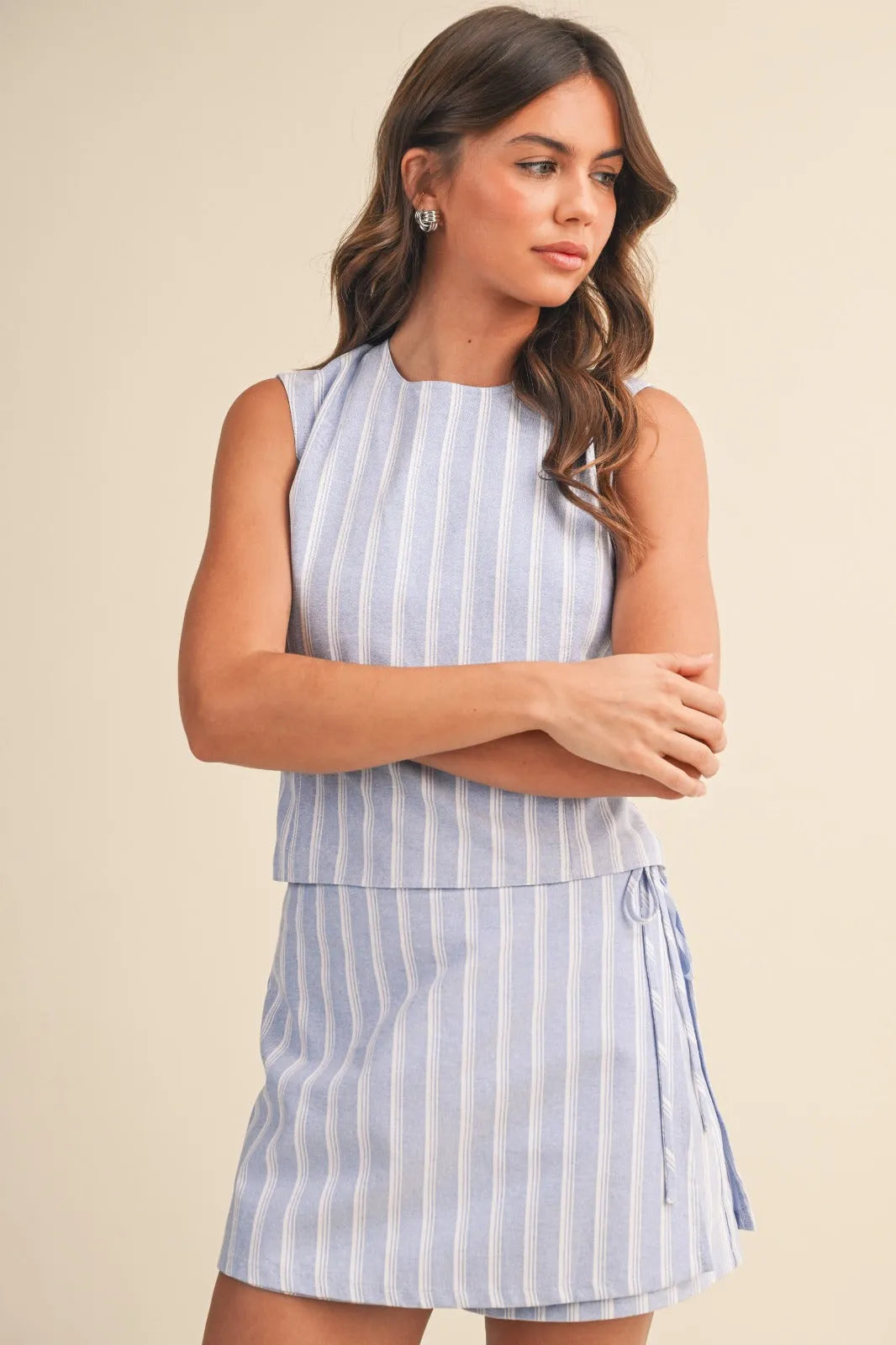A sleeveless light blue and white vertically striped zipper wrap skort with a tiered hemline for casual wear