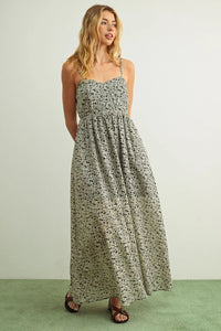 A flowing sleeveless floral print maxi dress in soft sage green fabric with delicate black floral embroidery details