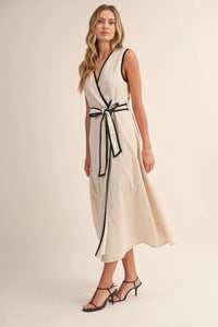 A sleeveless off-white midi dress with black contrast piping wrap along the neckline and waistband