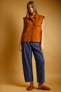 A sleeveless rust-orange chiffon blouse with front pockets and button front collar for stylish layering
