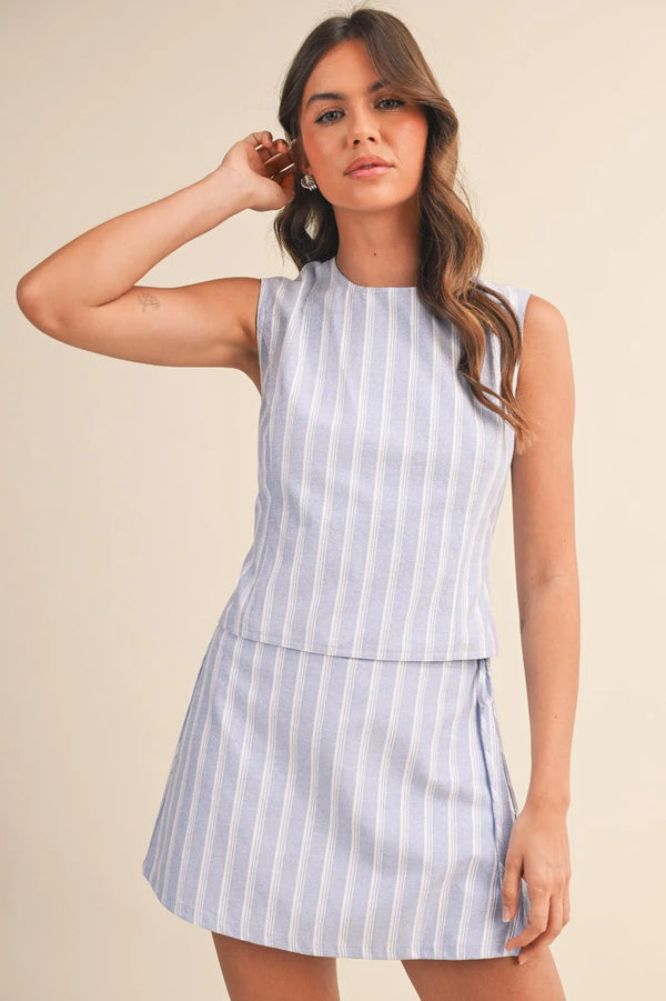 Sleeveless tie top in light blue and white stripe open design with tiered hem for women’s boho chic clothing