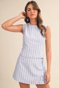A sleeveless zipper wrap skort dress in light blue and white vertical stripes with a tiered design
