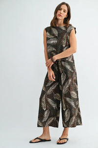 A sleeveless wide-leg jumpsuit in dark brown fabric with leaf print elastic waist and white all-over leaf print