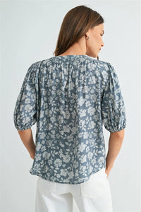 A soft blue v neck smocking detail blouse with puffed sleeves and gathered neckline in women’s boho chic clothing
