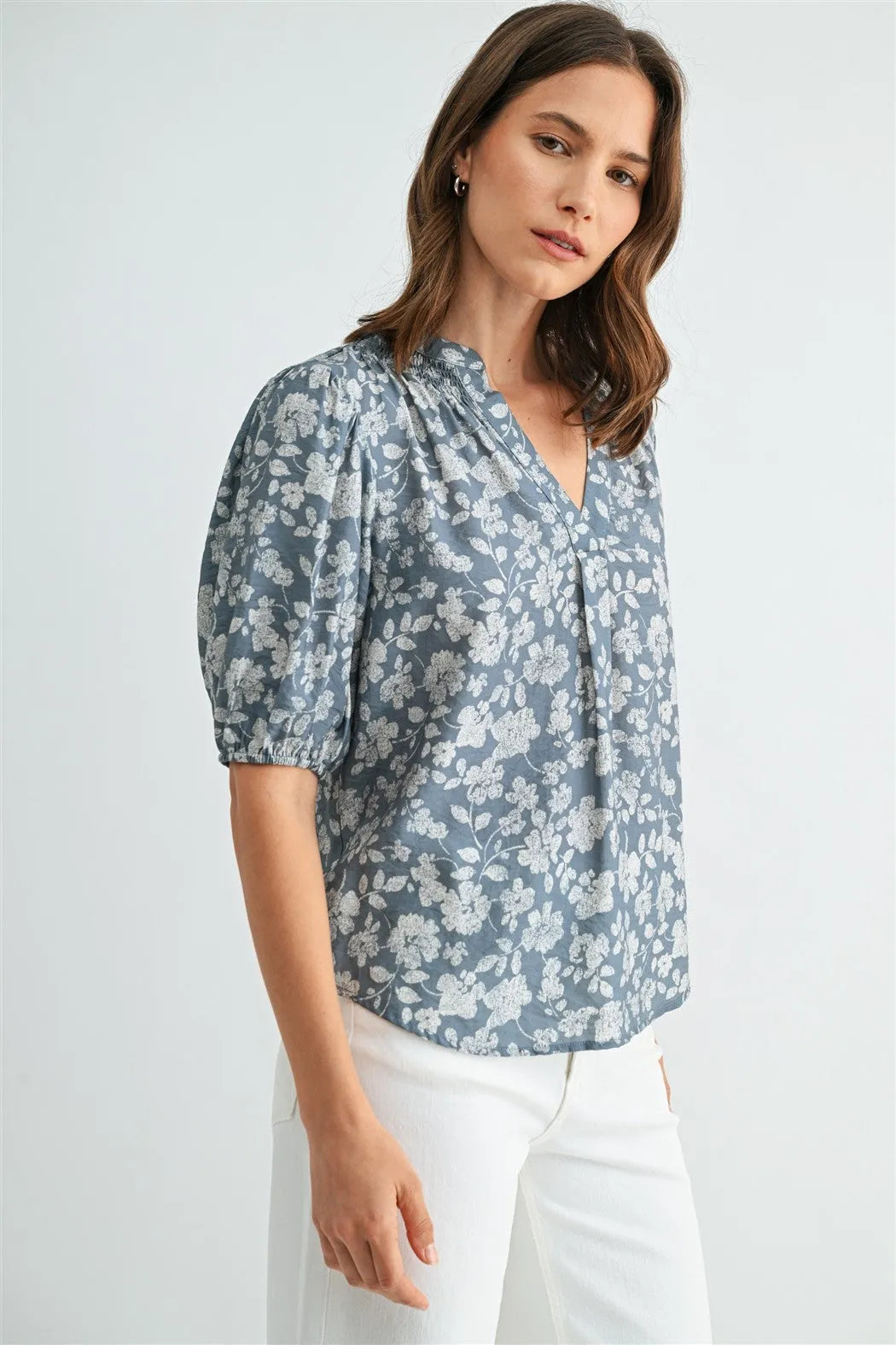 A soft blue v-neck smocking blouse with puffed sleeves and floral print in women’s boho chic clothing shop daisy