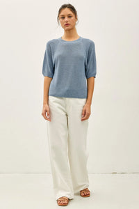 A soft blue lightweight ribbed knit top with three quarter sleeves and textured fabric for casual wear