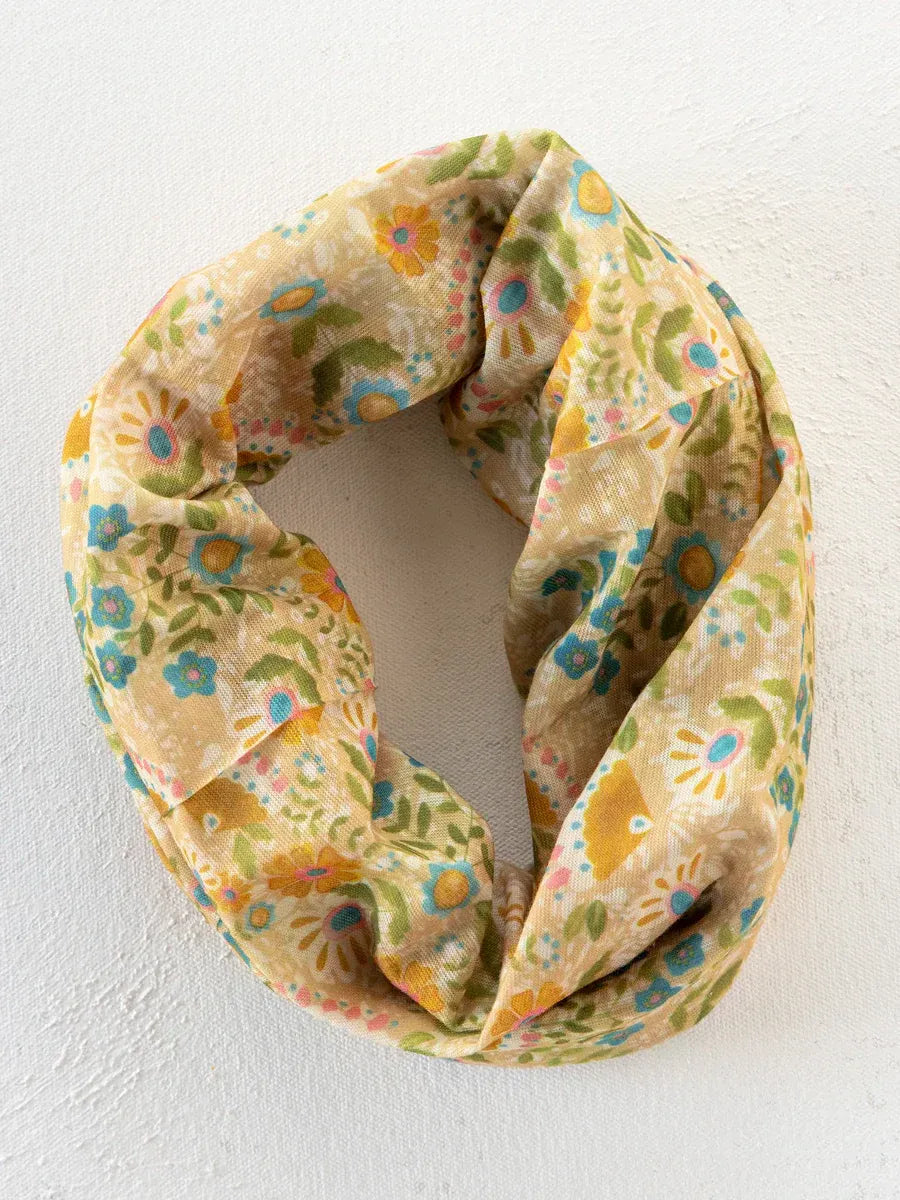 A soft cream-colored boho bandeau headband with taupe mandala floral pattern in yellow green and blue