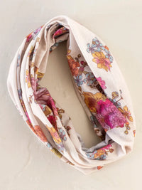 A soft cream-colored full boho bandeau headband in english garden cream with vibrant pink yellow and blue floral pattern