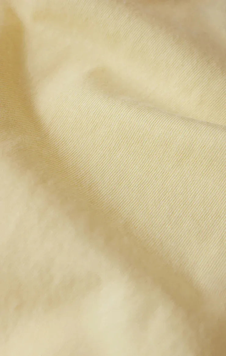 Soft creamy beige fabric with subtle woven texture in the shine tourist tee shirt for comfortable casual wear