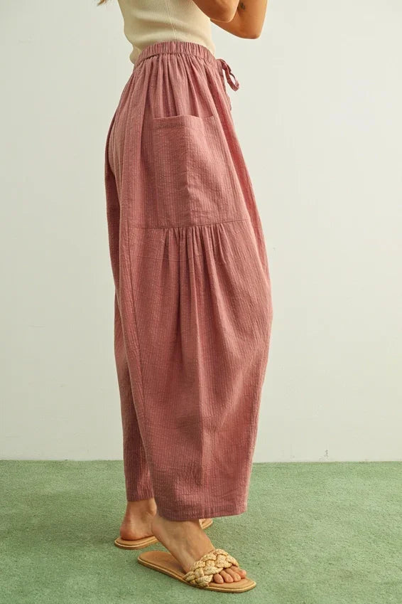 Soft dusty rose pinstriped loose pants with pockets, back view