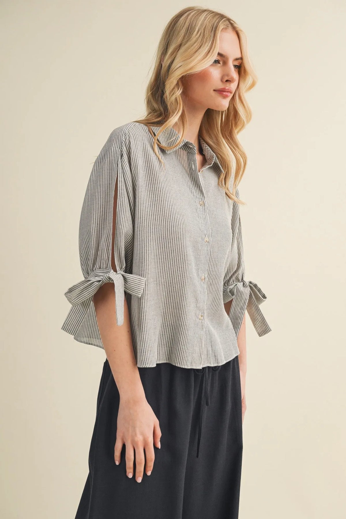 A soft gray and white striped tie cuff button up blouse with puffed sleeves tied at the cuffs