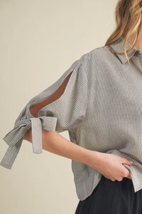 Soft gray and white striped tie cuff button front top with relaxed fit and cut-out sleeves tied into bows at cuffs