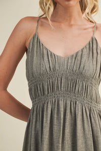 A soft heather gray maxi dress with shirred bodice spaghetti straps and a smocked waistband for elegant wear