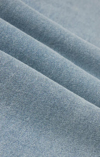 Soft light blue heritage knit denim jacket fabric with subtle textured weave showcasing premium knit denim material
