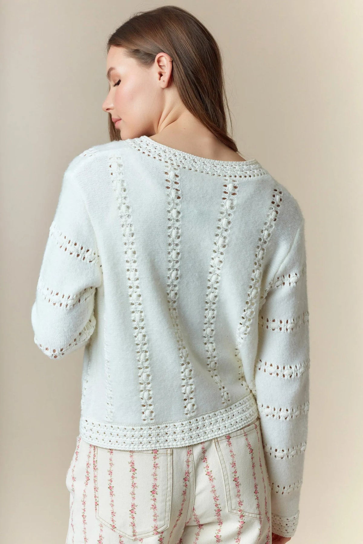 A soft light blue knit hole stripe bows cardigan with delicate lace-like cutout patterns on the back and cuffs