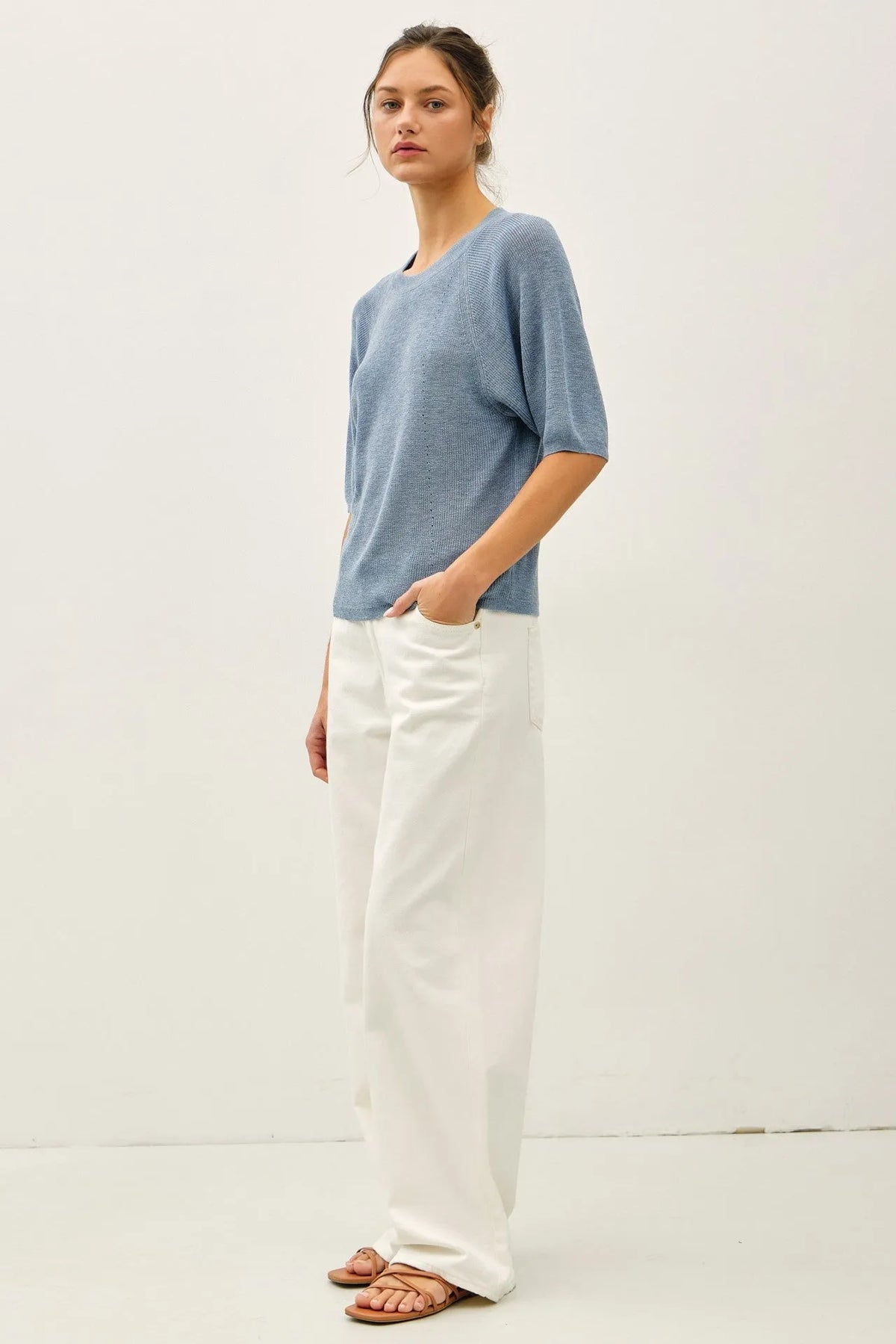 A soft light blue lightweight ribbed knit top with subtle texture and three-quarter sleeves in ribbed knit raglan style