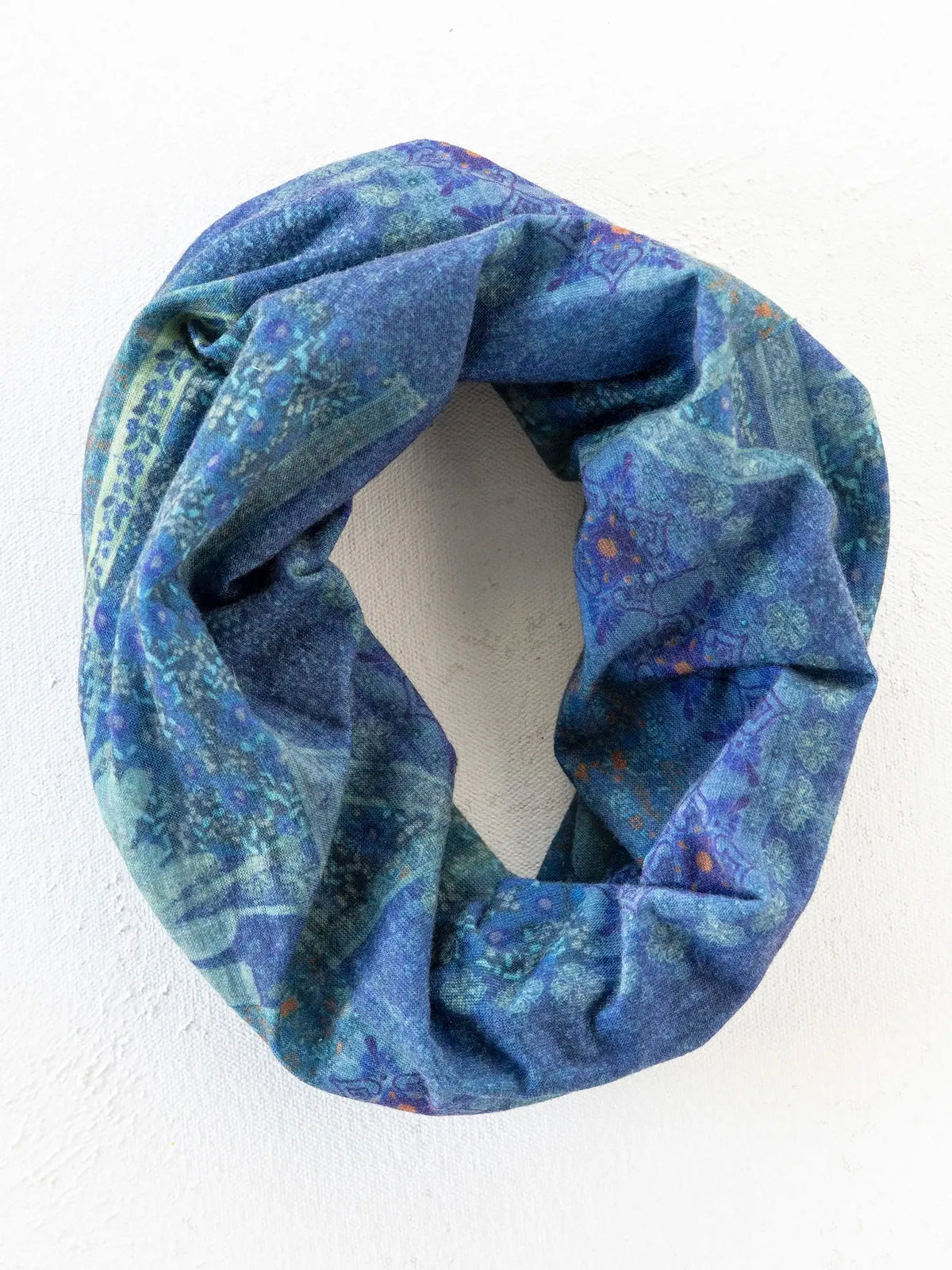 A soft looped boho bandeau headband in navy patchwork with subtle floral and abstract patterns