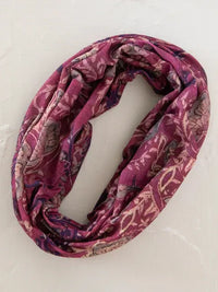A soft maroon boho bandeau headband with a floral and paisley pattern in muted pink and purple tones