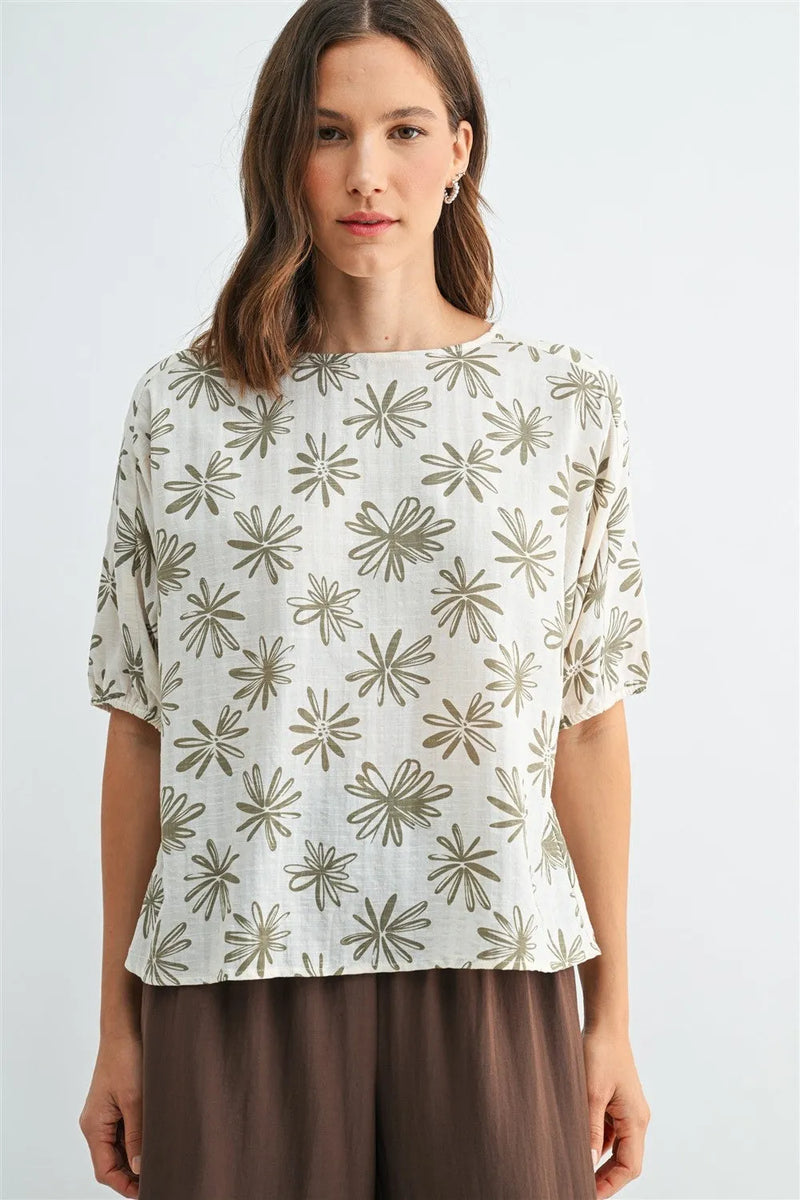 A soft off-white flower print dolman sleeve blouse with subtle olive-green starburst pattern and short sleeves