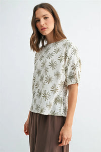 A soft off-white flower print dolman sleeve blouse with a delicate olive-green starburst pattern and short puffed sleeves