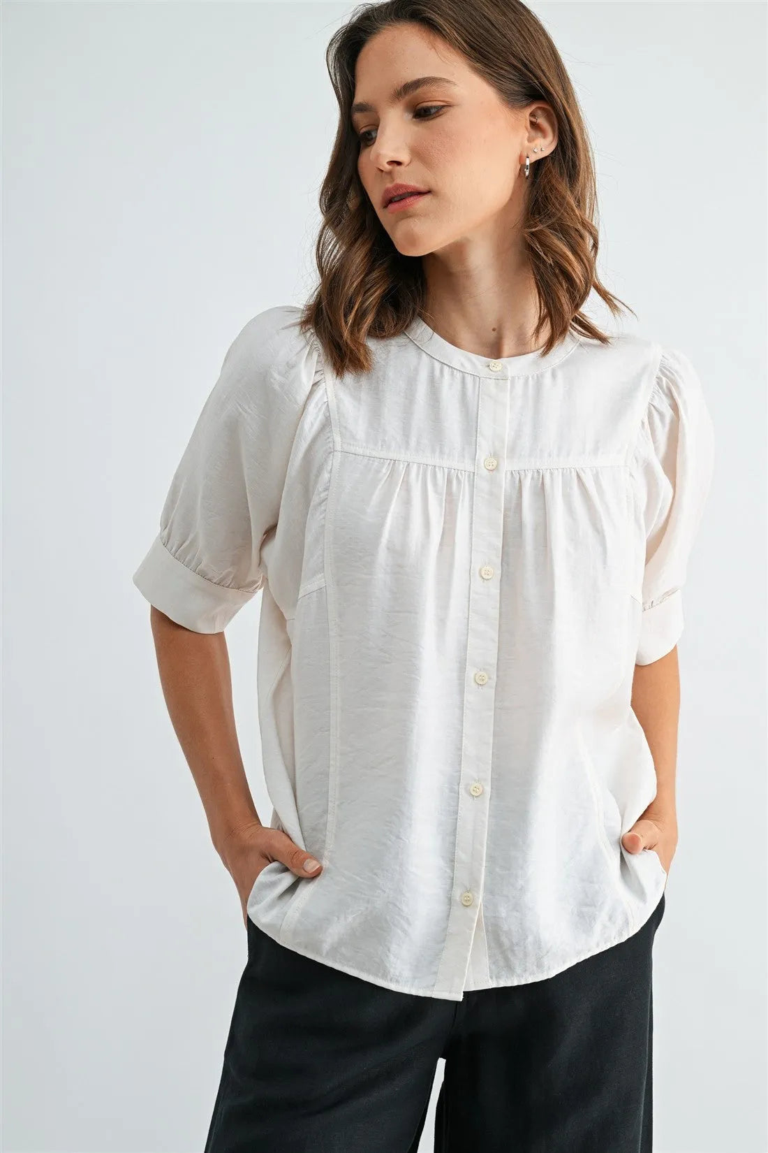 A soft off-white cotton button down short sleeve blouse with a relaxed fit and front buttons