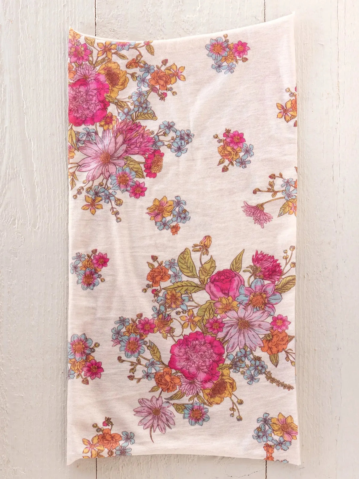A full boho bandeau headband in english garden cream features soft off-white cotton with vibrant floral patterns