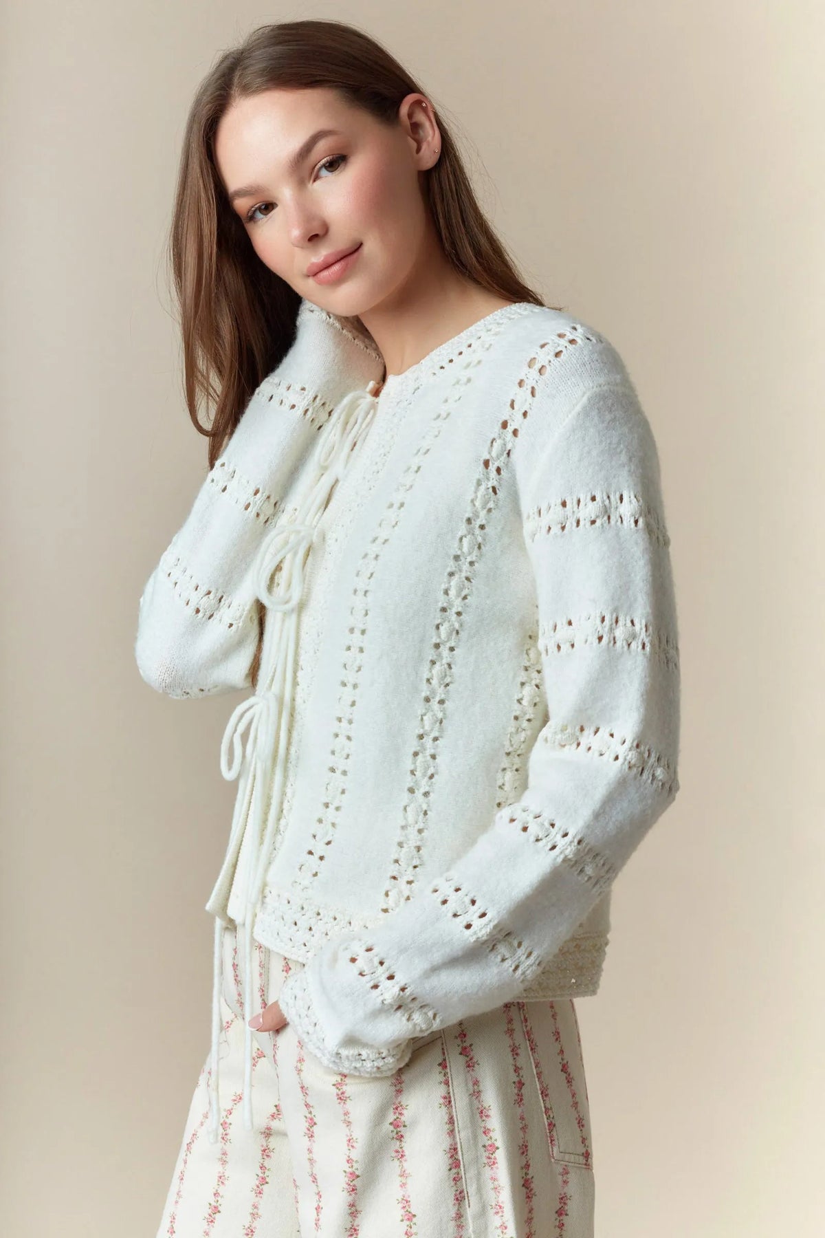 A soft off-white knit hole stripe bows front tie cardigan with delicate eyelet lace detailing