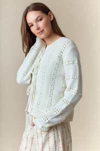 A soft off-white knit hole stripe bows front tie cardigan with delicate eyelet lace detailing