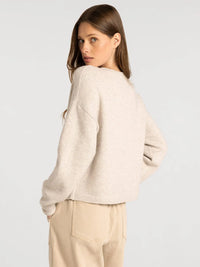 A soft off-white knit dover button cardigan with relaxed fit and ribbed cuffs from supply dover collection