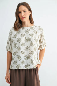 A soft off-white linen flower print dolman blouse with delicate olive-green starburst pattern across the fabric