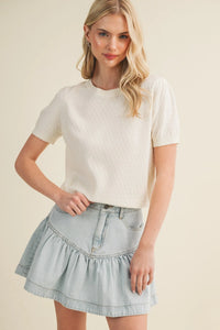 A soft off-white starburst pointelle puff sleeve top with subtle textured knit and scalloped hem detail