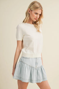 A soft off-white starburst pointelle puff sleeve top with relaxed fit and subtle ruffled hem for casual wear
