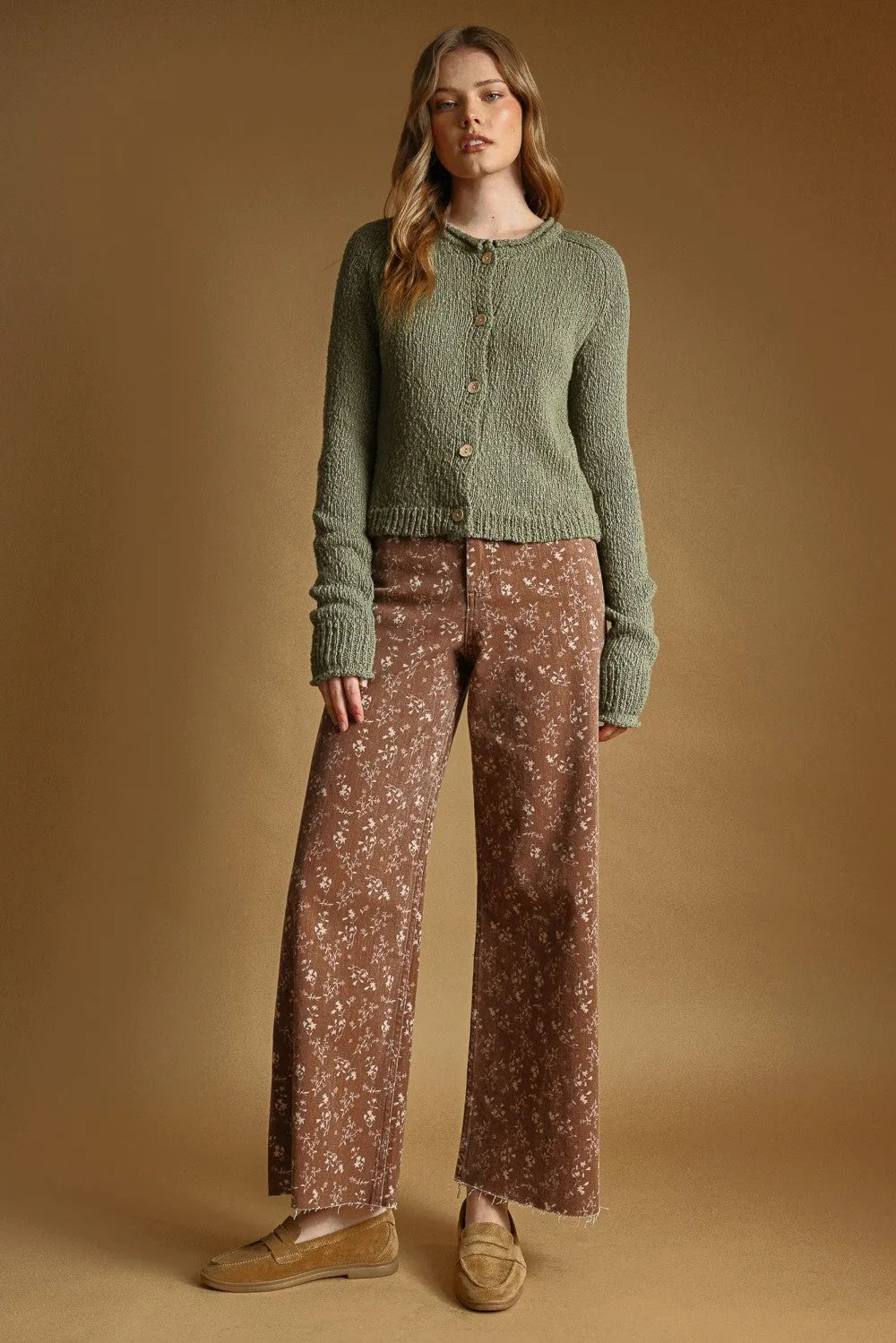 A soft olive green sweater knit cardigan with button front and ribbed cuffs made of knitted fabric