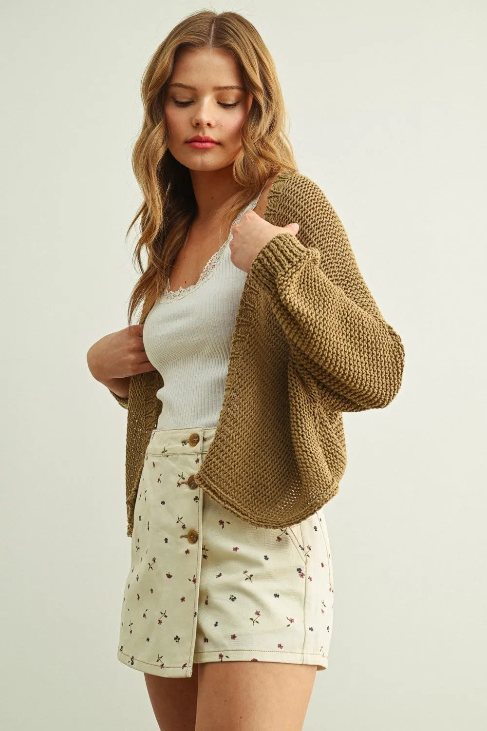 A soft olive-green long sleeve cropped cardigan with textured weave and relaxed fit in knitted fabric