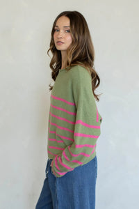 A soft olive green quarter stripe piper pullover sweater with vibrant pink horizontal stripes and relaxed fit long sleeves