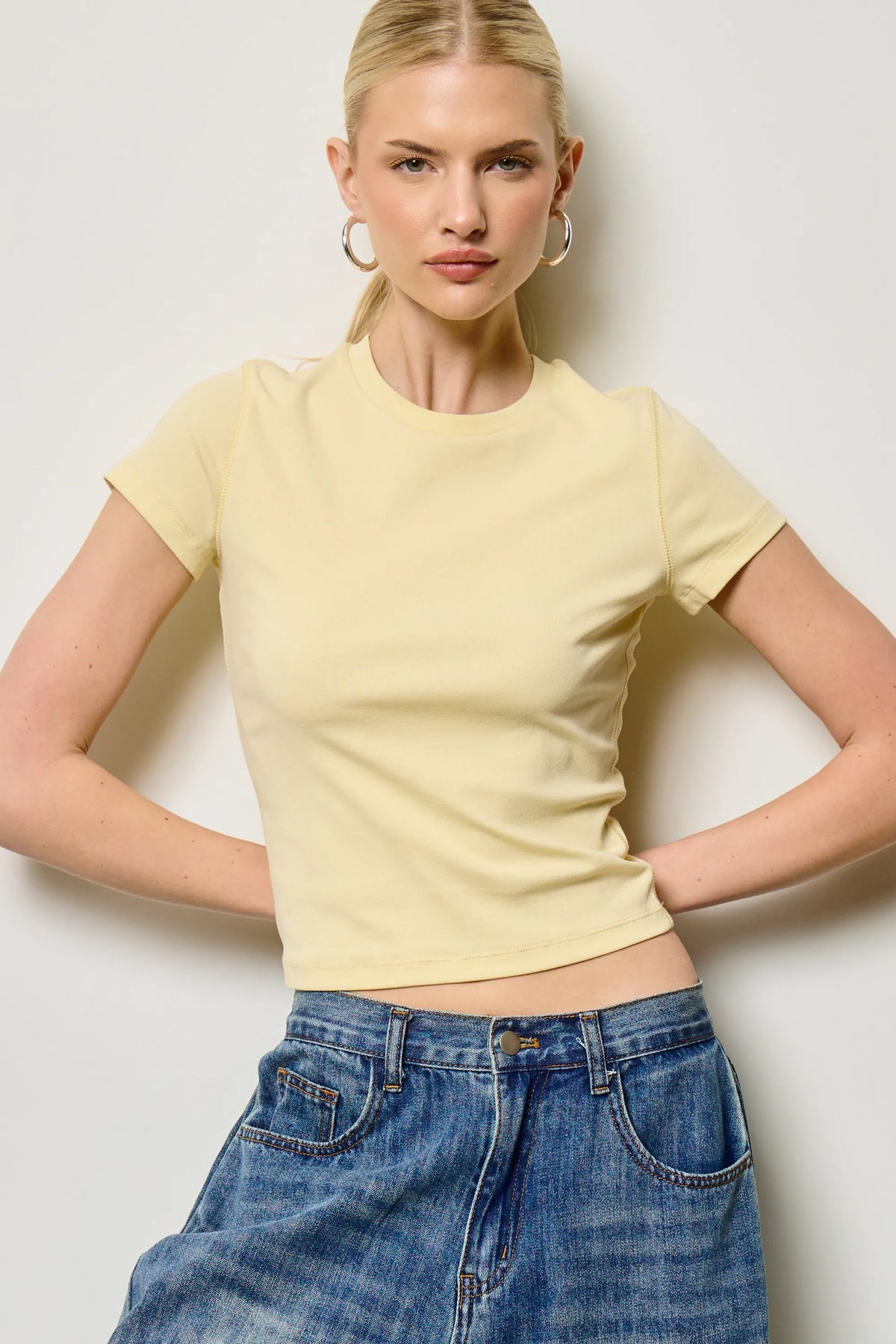 A soft pale yellow fitted crewneck baby tee with short sleeves and subtle ribbed texture perfect for casual wear