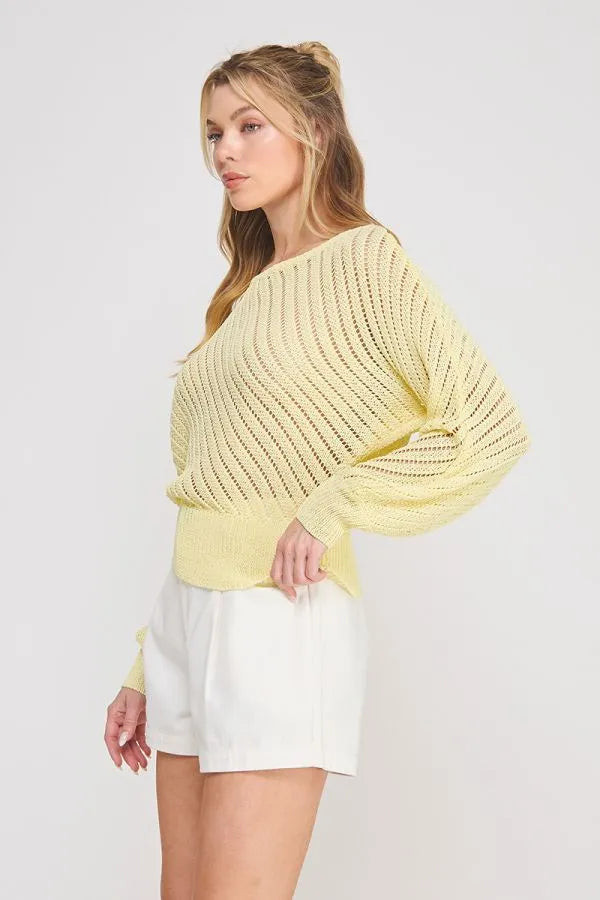 A soft pale yellow hand yarn open stitch dolman sweater top with ribbed texture and loose flowing sleeves