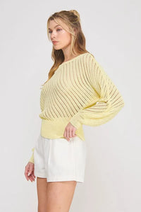 A soft pale yellow hand yarn open stitch dolman sweater top with ribbed texture and loose flowing sleeves