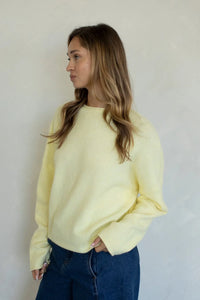 A soft pale yellow oversized soft piper long-sleeved knit pullover sweater with a relaxed fit